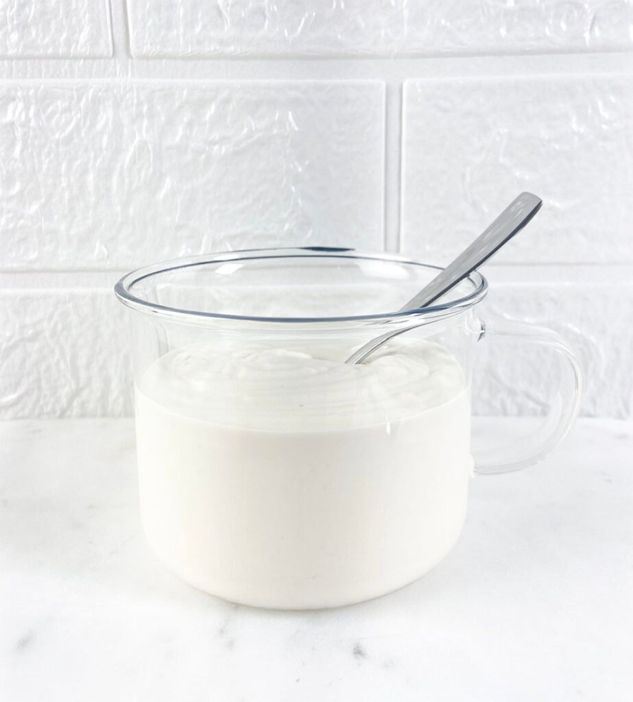 Visão do creme de leite feito sem lácteos e vegano em uma xícara