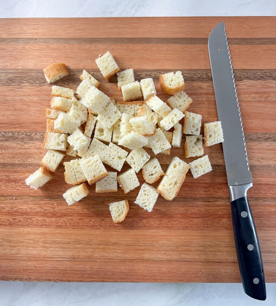 Visão do primeiro passo para fazer a farinha de rosca sem glúten: corte o pão em pedaços pequenos